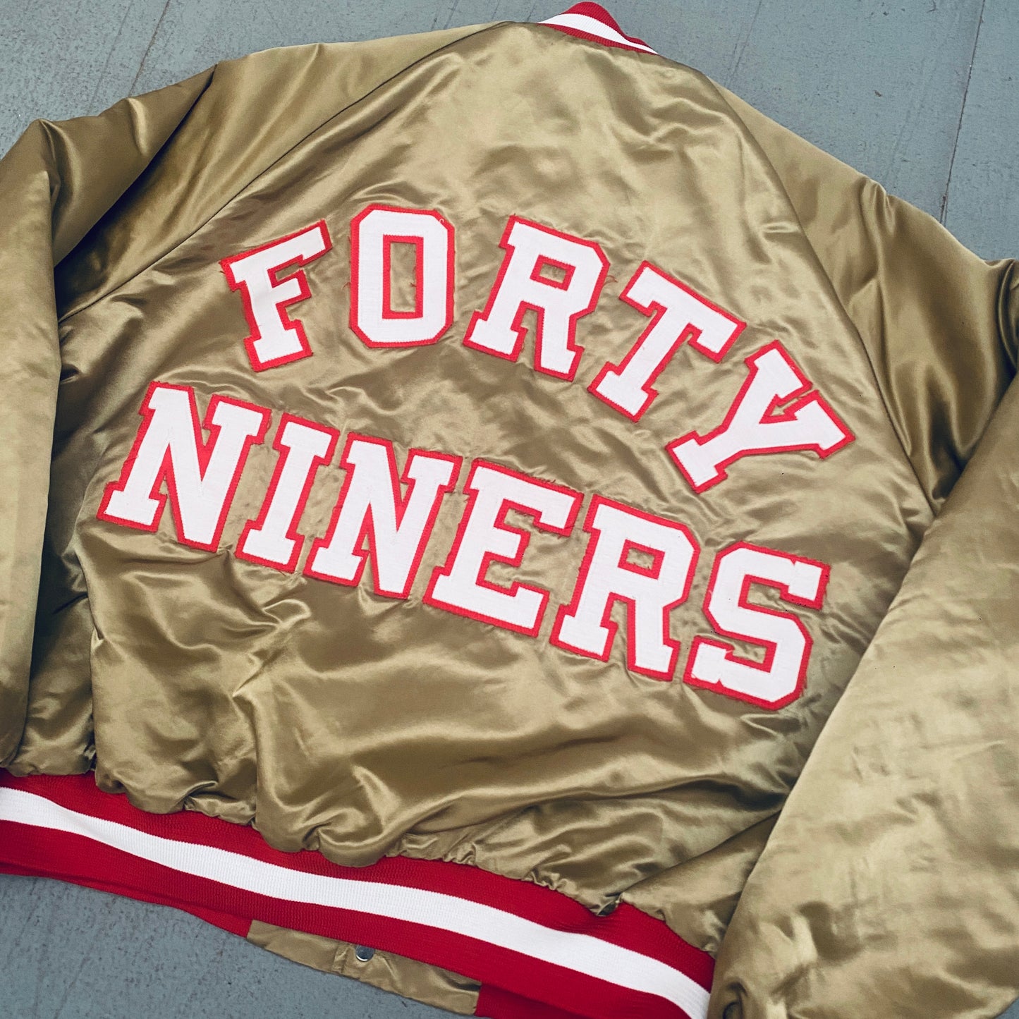 San Francisco 49ers: 1980's Chalk Line Satin Reverse Stitched Spellout Bomber Jacket (XL)